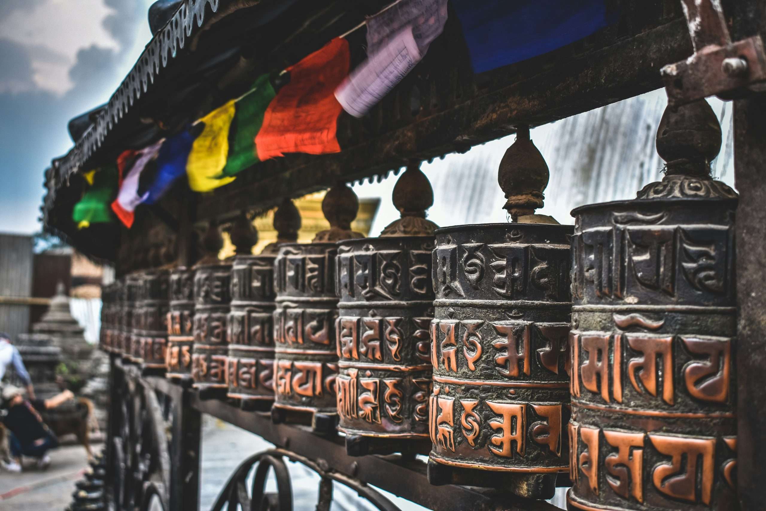 Prayer wheels in a row outside a temple | Photo by Tim van Kempen on Unsplash