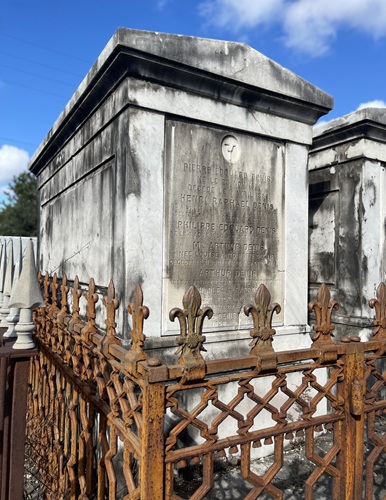 Denis Family Tomb, an above ground rectangular tomb from the early 1800s surrounded by an elaborate rusting wrought iron fence in St Louis Cemetery No. 1, New Orleans